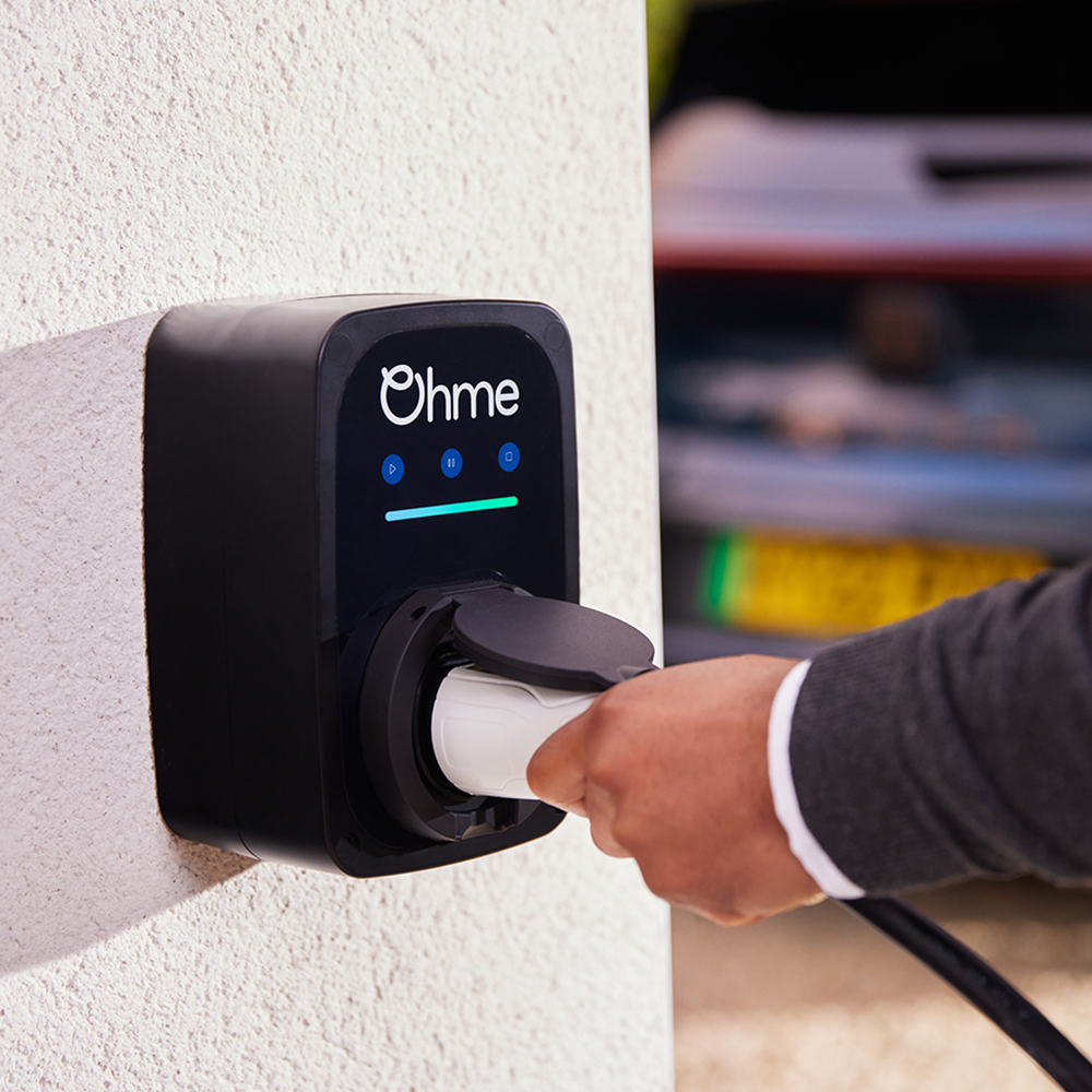 Ohme EV charger in use at home, showing charging cable being connected to the unit – available from Evergy, Thame’s local EV charger supplier.